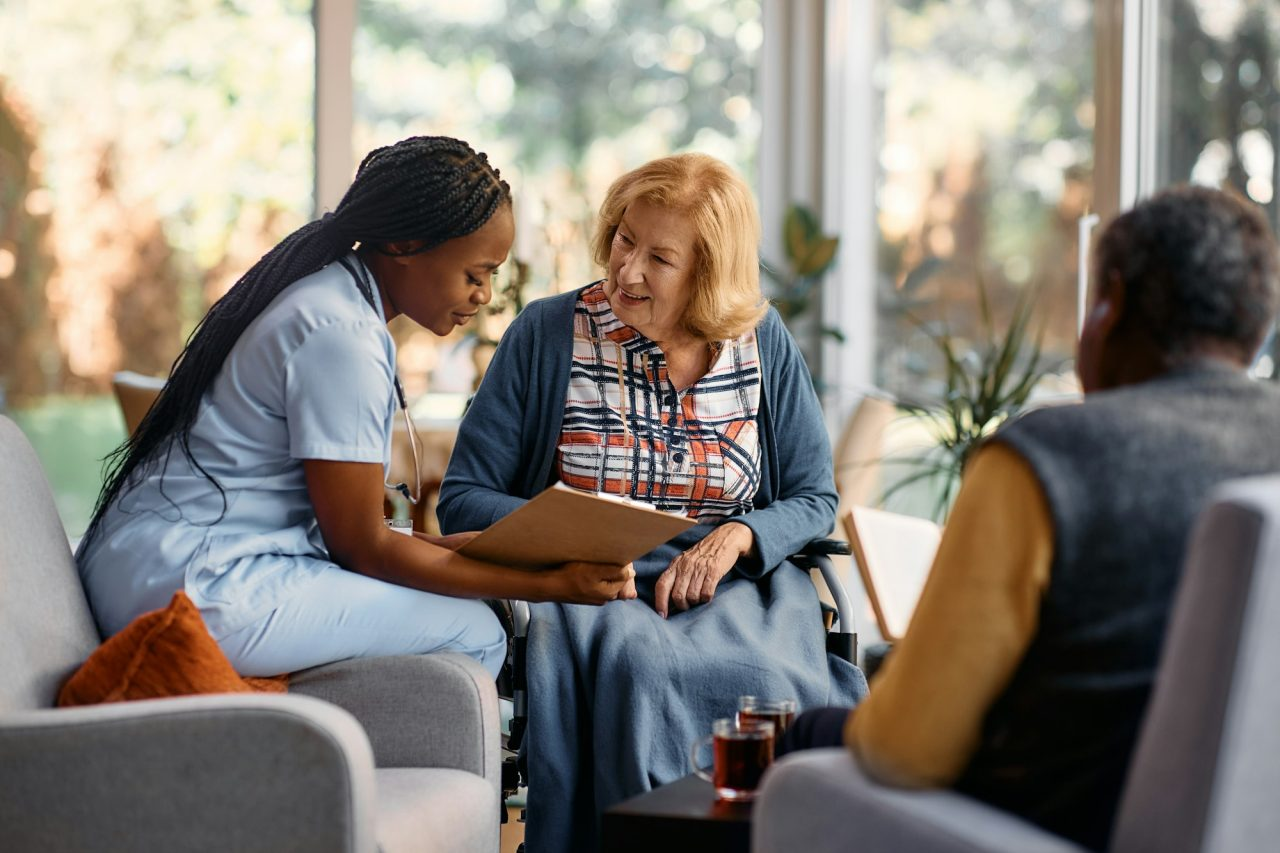 A support professional reviewing a plan with two wheelchair users